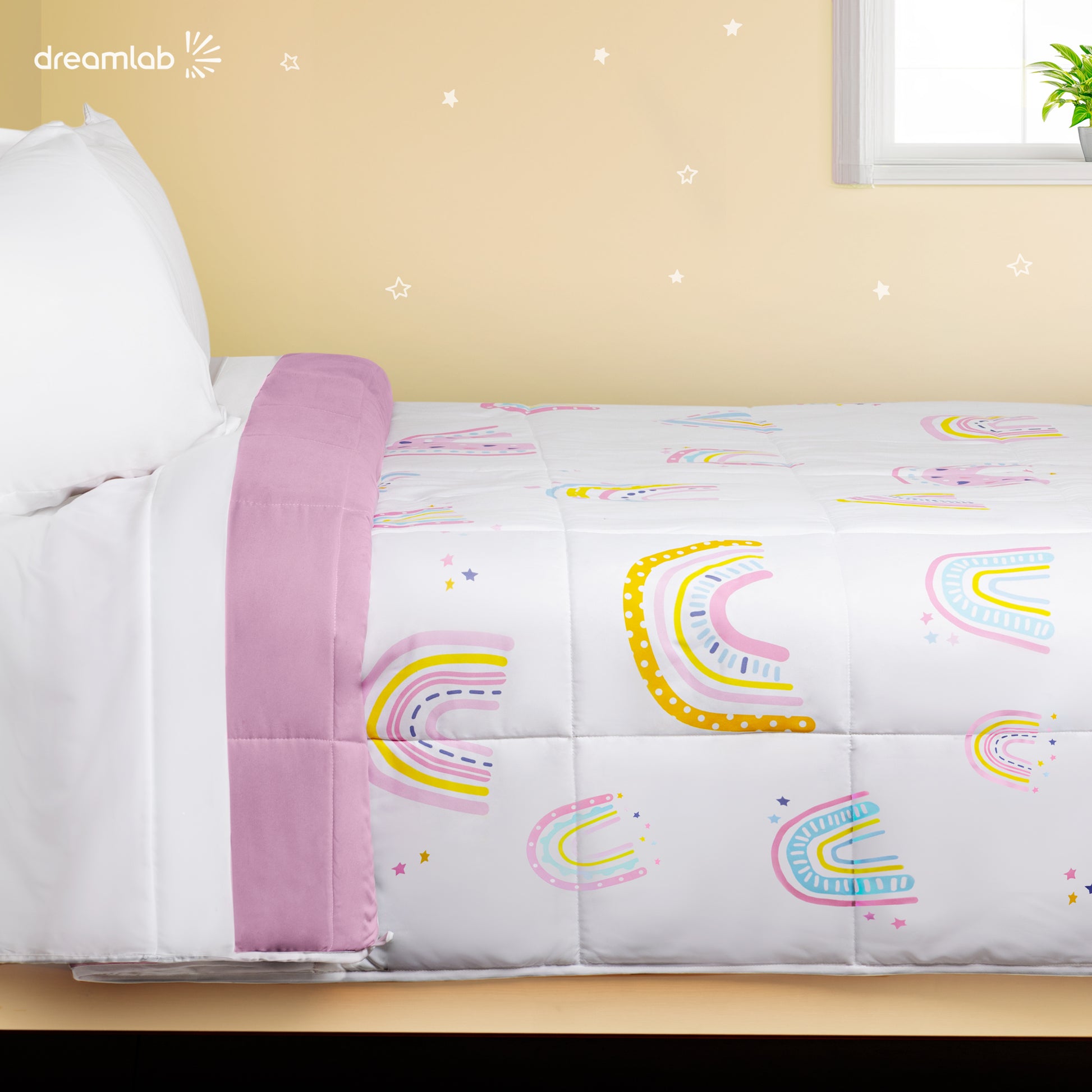 Edredón infantil con diseño arcoíris fondo blanco y reverso rosa, para cama matrimonial o individual, suave y ligero.
