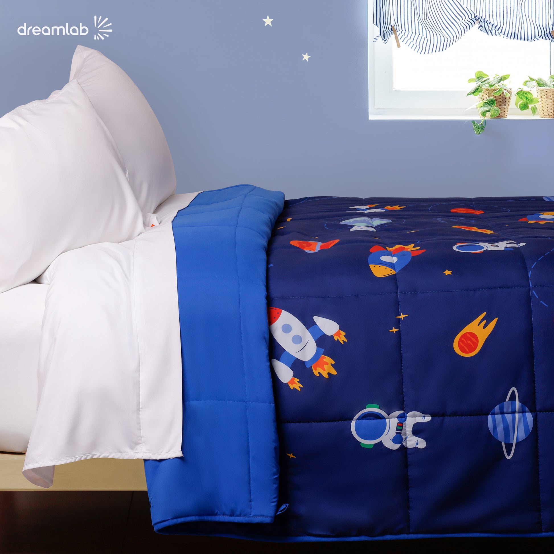 Edredón reversible con diseño de astronautas y estrellas, brindando un toque de aventura espacial a la habitación infantil.
